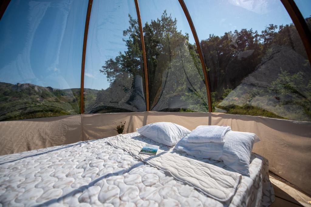 Bett in einem Zelt vor einem Fenster in der Unterkunft Rtanj hotel sa 1000 zvezdica 2 in Vrmdža