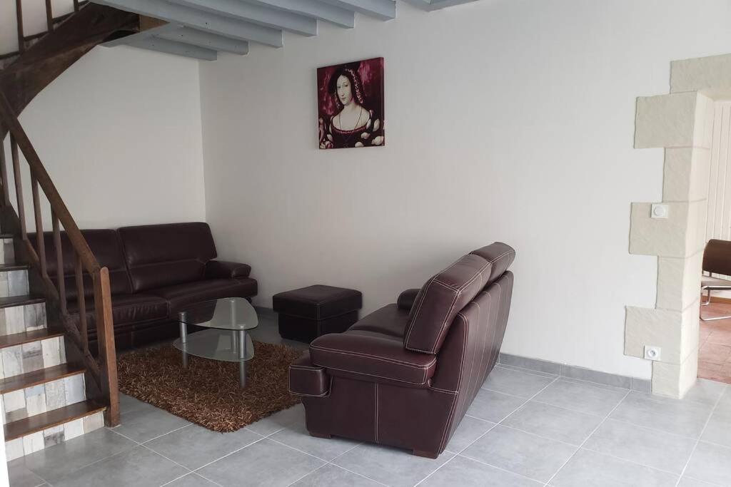 sala de estar con sofá de cuero y escalera en Maison familiale à 10min du Zoo Parc de Beauval, en Saint-Romain-sur-Cher