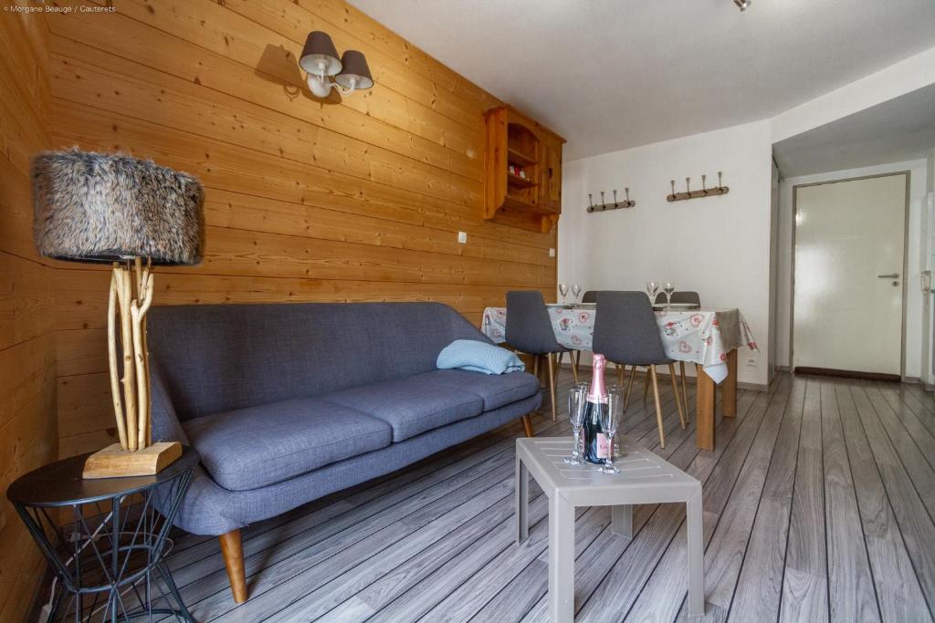 a living room with a couch and a table at Appartement centre ville parking balcon et wi fi in Cauterets