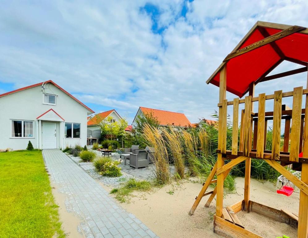 a backyard with a playground and a house at Magic Home Łeba in Łeba