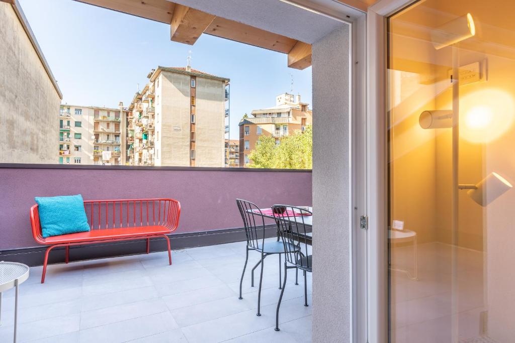 un balcón con un banco rojo y una mesa en ALTIDO Contemporary apartments in historical Giambellino-Lorenteggio, en Milán