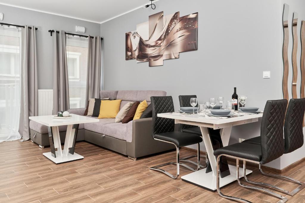 salon z kanapą, stołem i krzesłami w obiekcie Apartments Wrocław Jana Pawła II with FREE PARKING Wrocław by Noclegi Renters we Wrocławiu