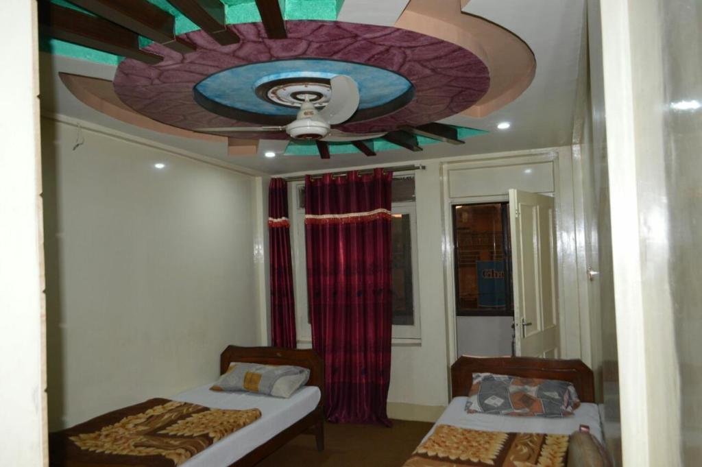 sypialnia z 2 łóżkami i sufitem w obiekcie Hotel Deluxe w mieście Kachāhri