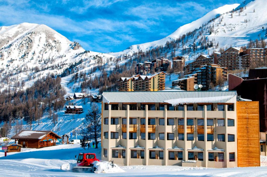 a hotel in the snow next to a mountain at SOWELL RESIDENCES New Chastillon in Isola 2000