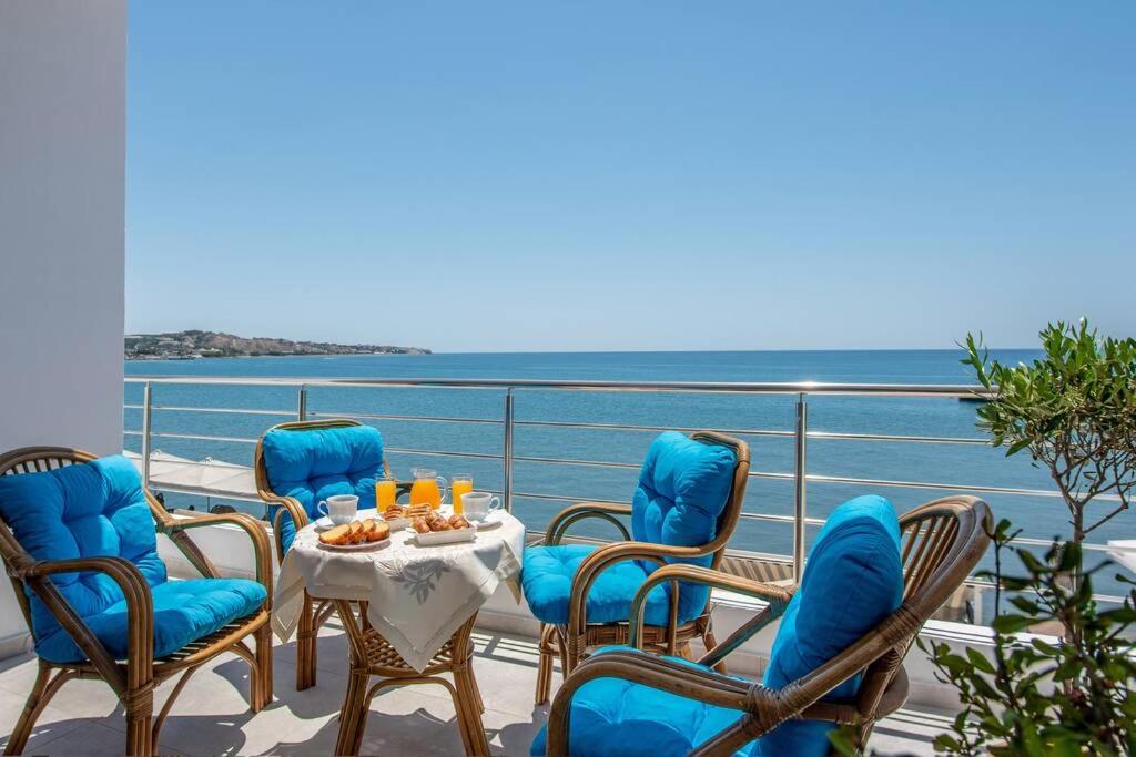 a balcony with a table and chairs and the ocean at Amazing Seafront Suite in Ierápetra
