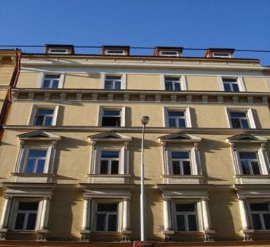 プラハにあるペンション イージー ジャーニーの多くの窓と青空を持つ大きな建物