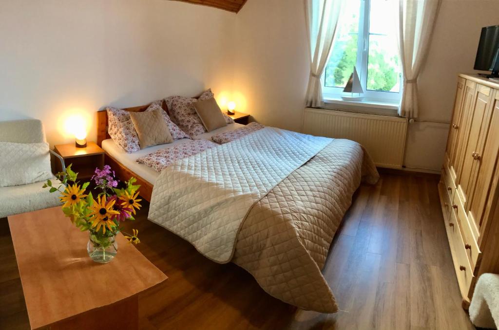 ein Schlafzimmer mit einem Bett und einer Vase aus Blumen in der Unterkunft Chalupa Václav Lipno in Lipno nad Vltavou