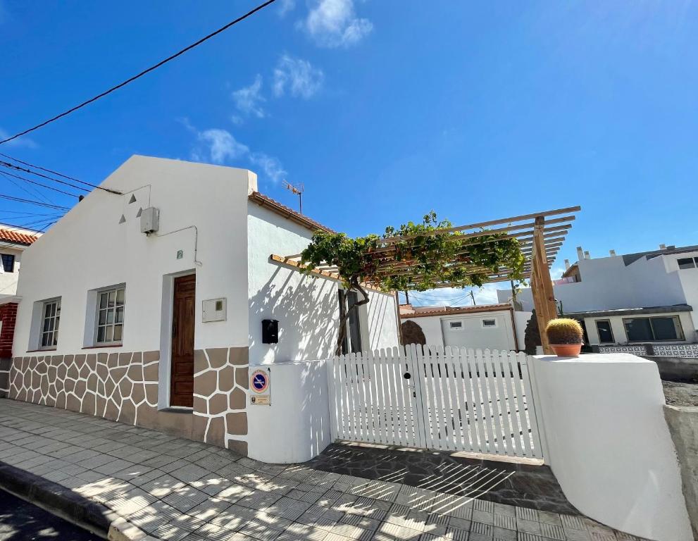 une maison blanche avec une clôture blanche dans l'établissement La Casita de la Parra, El Hierro, à Tamaduste