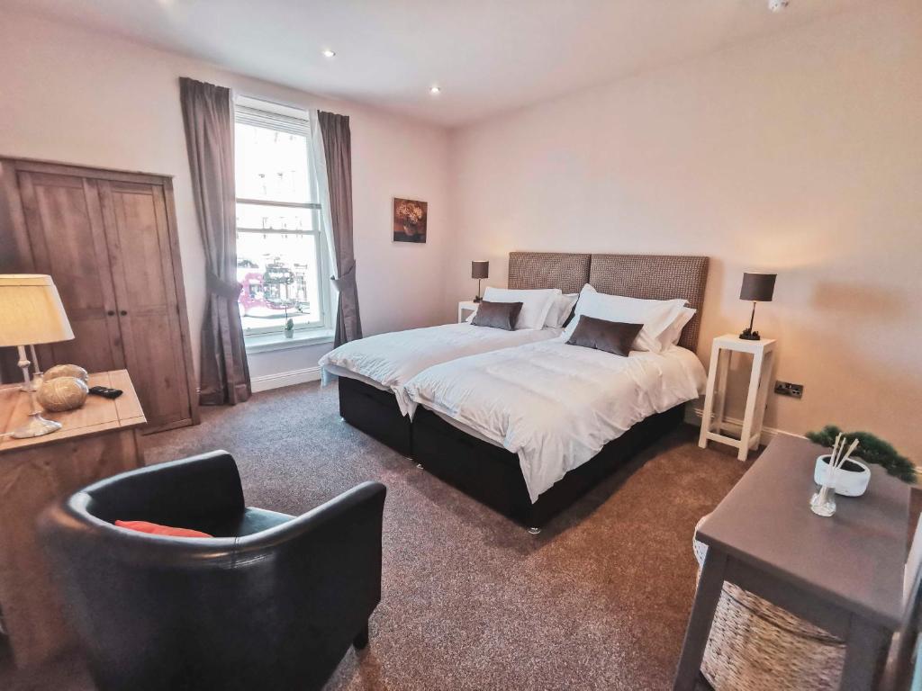 una camera con un letto e una sedia di The Ship Inn a Musselburgh
