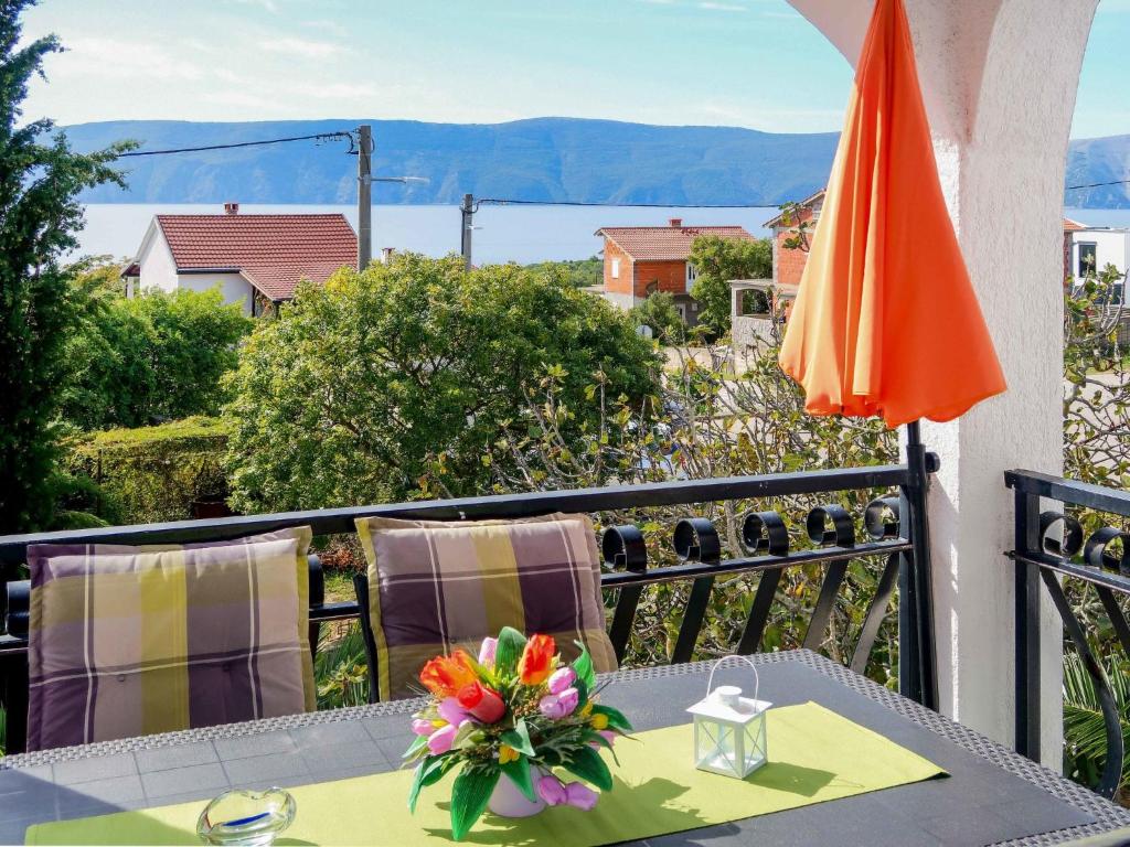 una mesa en un balcón con sombrilla naranja en Apartment Dilly - KRK116 by Interhome en Pinezici