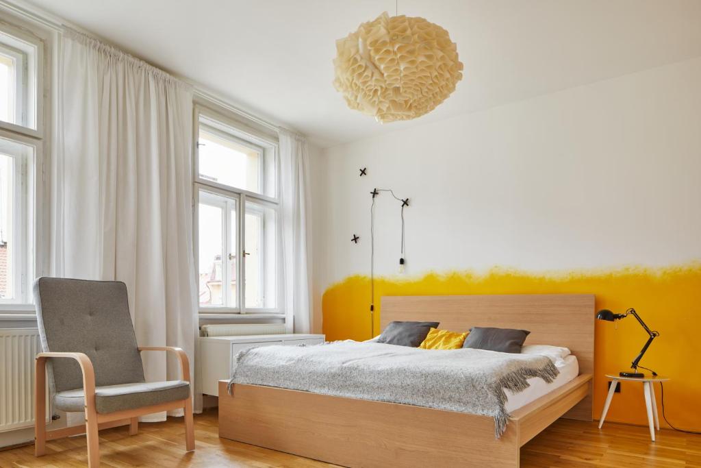 1 dormitorio con 1 cama, 1 silla y 1 lámpara de araña en Cozy Flat in New Town by Prague Days en Praga