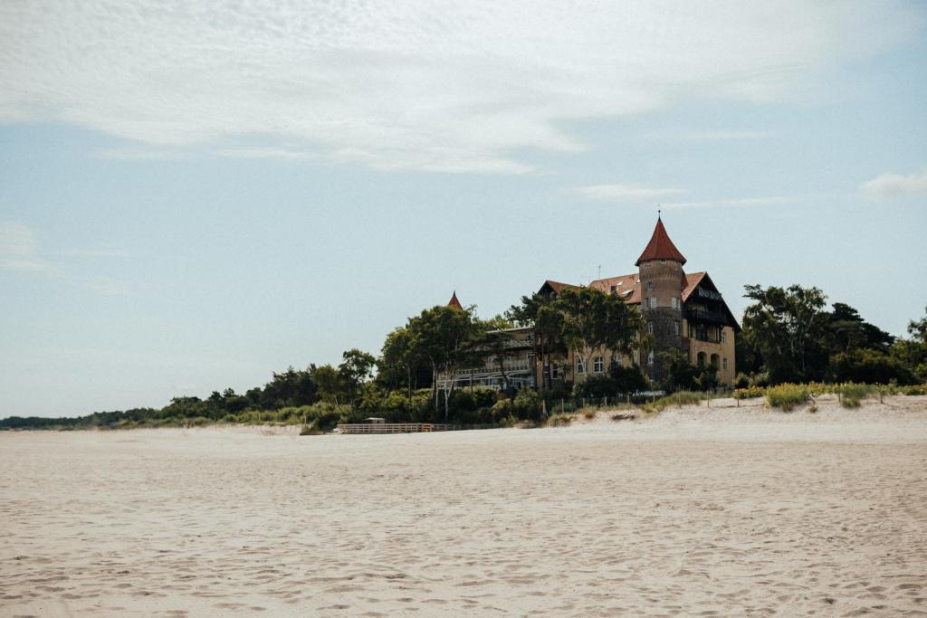 a house on an island in the middle of a beach at Zamek Łeba Resort & Spa in Łeba