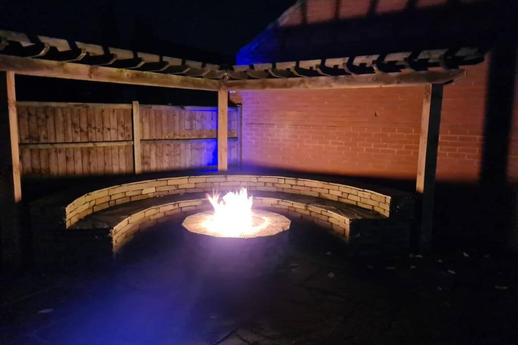 a brick oven with a fire in it at night at Detached luxury 5 bed house, lanscaped garden, fire pit, parking, can sleep families or workers in Hockering
