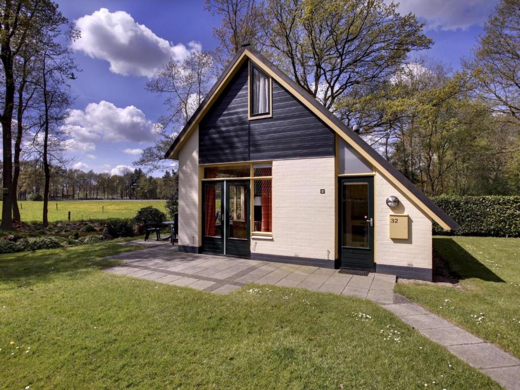 une petite maison à la façade noire et blanche dans l'établissement Holiday Home Buitenplaats Gerner-8 by Interhome, à Dalfsen