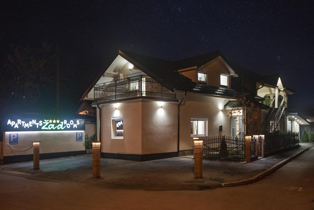een huis met 's nachts een bord ervoor bij ŽAD Apartments and Rooms in Banja Luka