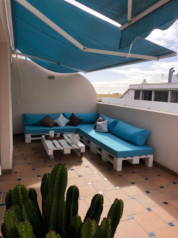 un patio con sofá y un cactus en el techo en Ático Los Rombos, en Puerto Naos