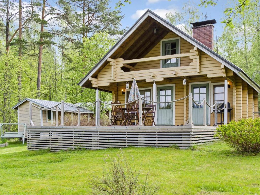 a log cabin in the woods with a porch at Holiday Home Lietukka by Interhome in Outokumpu