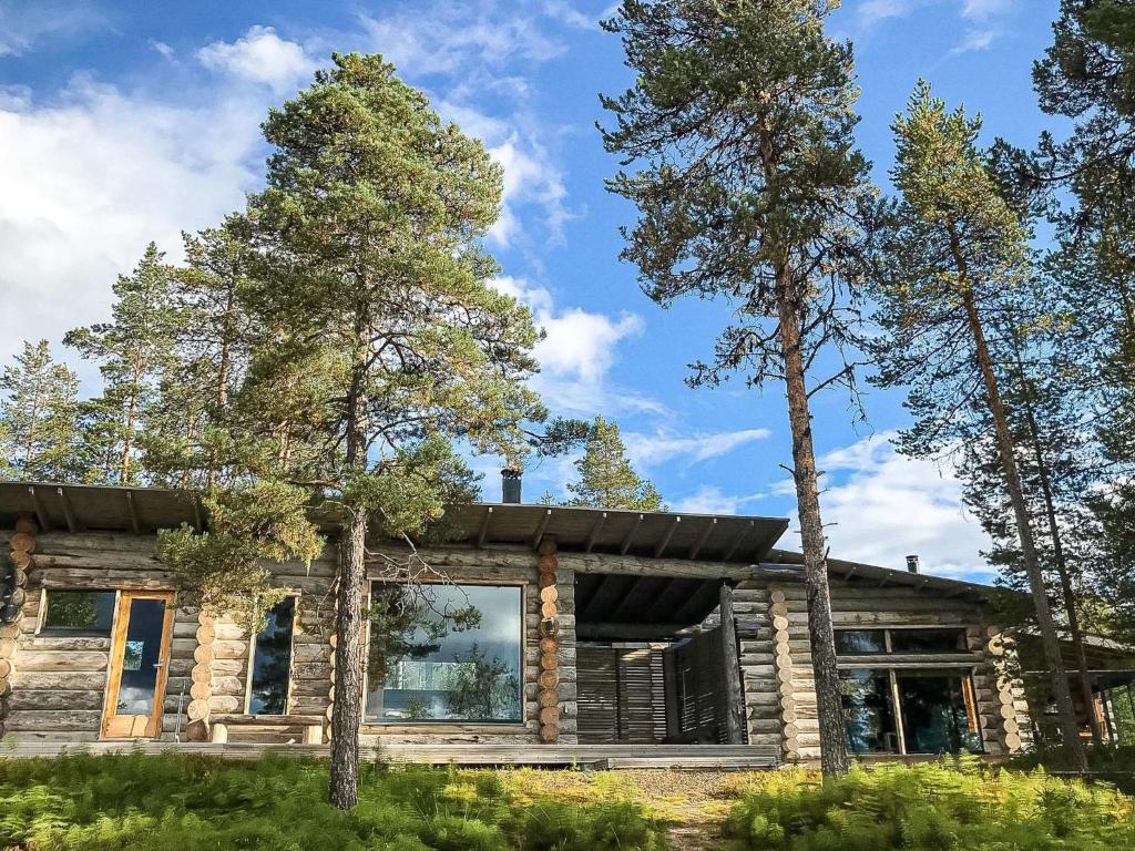 a log cabin with trees in front of it at Holiday Home Jussis chalet a by Interhome in Kuusamo