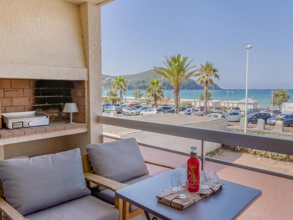 une table et des chaises sur un balcon avec vue sur la plage dans l'établissement Apartment La Rose des Sables by Interhome, à Saint-Cyr-sur-Mer