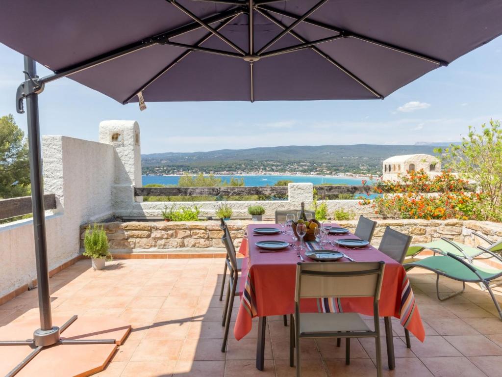 un patio avec une table et un parasol dans l'établissement Apartment Hameau la Madrague-27 by Interhome, à Saint-Cyr-sur-Mer