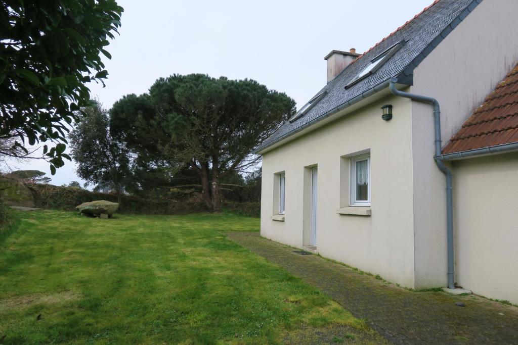 une maison blanche avec un mouton dans la cour dans l'établissement Maison avec jardin à 400m de la plage à Landrellec en PLEUMEUR-BODOU Ref 250, à Pleumeur-Bodou
