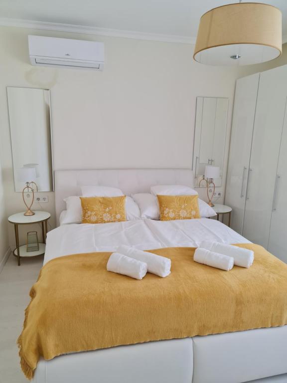 a large white bed with two towels on it at Kolibri Apartman in Szeged