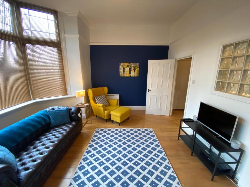 a living room with a couch and a television at Stylish Apartment With Secure Parking Close to City in Chester