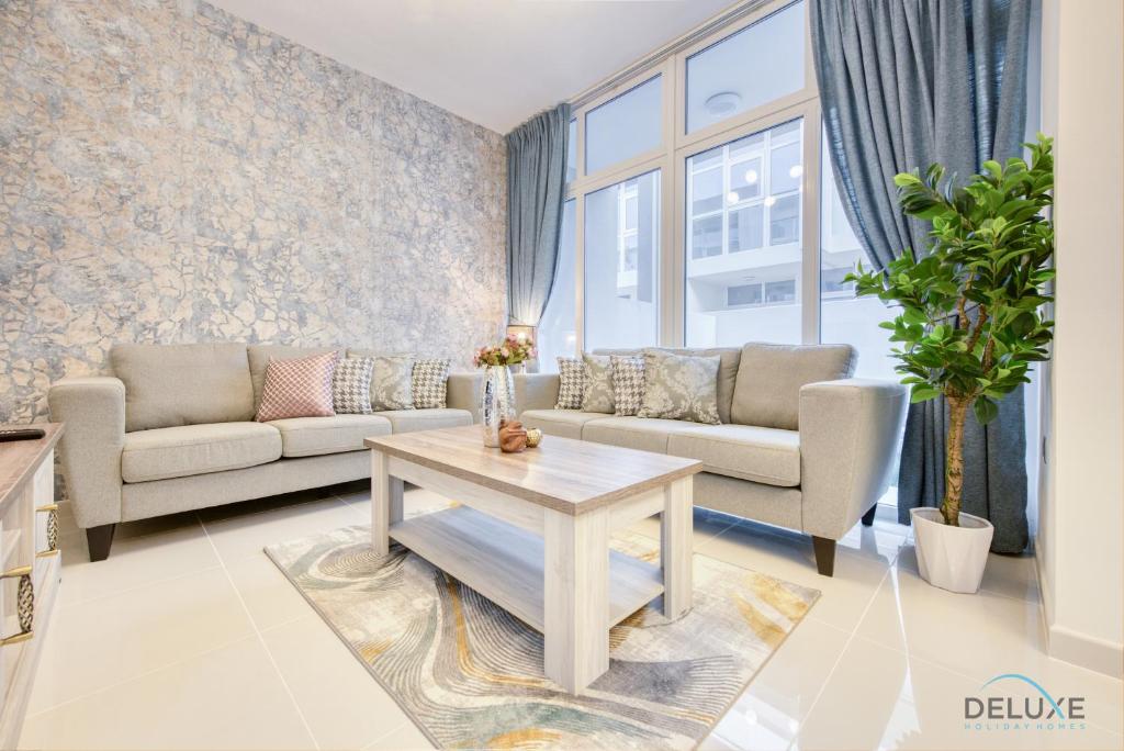 a living room with a couch and a table at Opulent 3BR Townhouse at DAMAC Hills 2 Dubailand by Deluxe Holiday Homes in Dubai