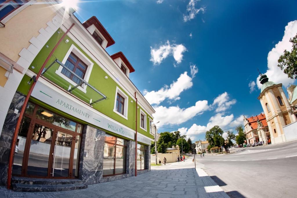 um edifício verde ao lado de uma rua em Willa Pod Bramą em Sandomierz