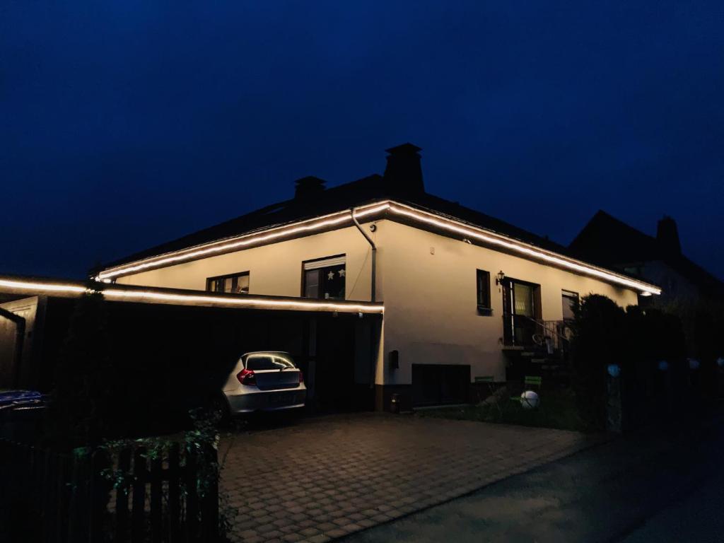 a white house with a car parked in front of it at Maja Ferienwohnung in Goddelsheim