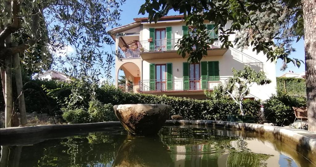 ein Haus mit einem Teich vor einem Gebäude in der Unterkunft San Bartolo Rent Apartments, due passi da Firenze in Fiesole