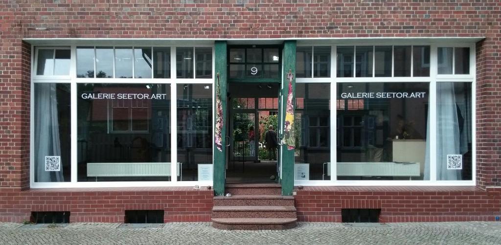 a brick building with the entrance to a store at Gästewohnung SEETOR in Lenzen