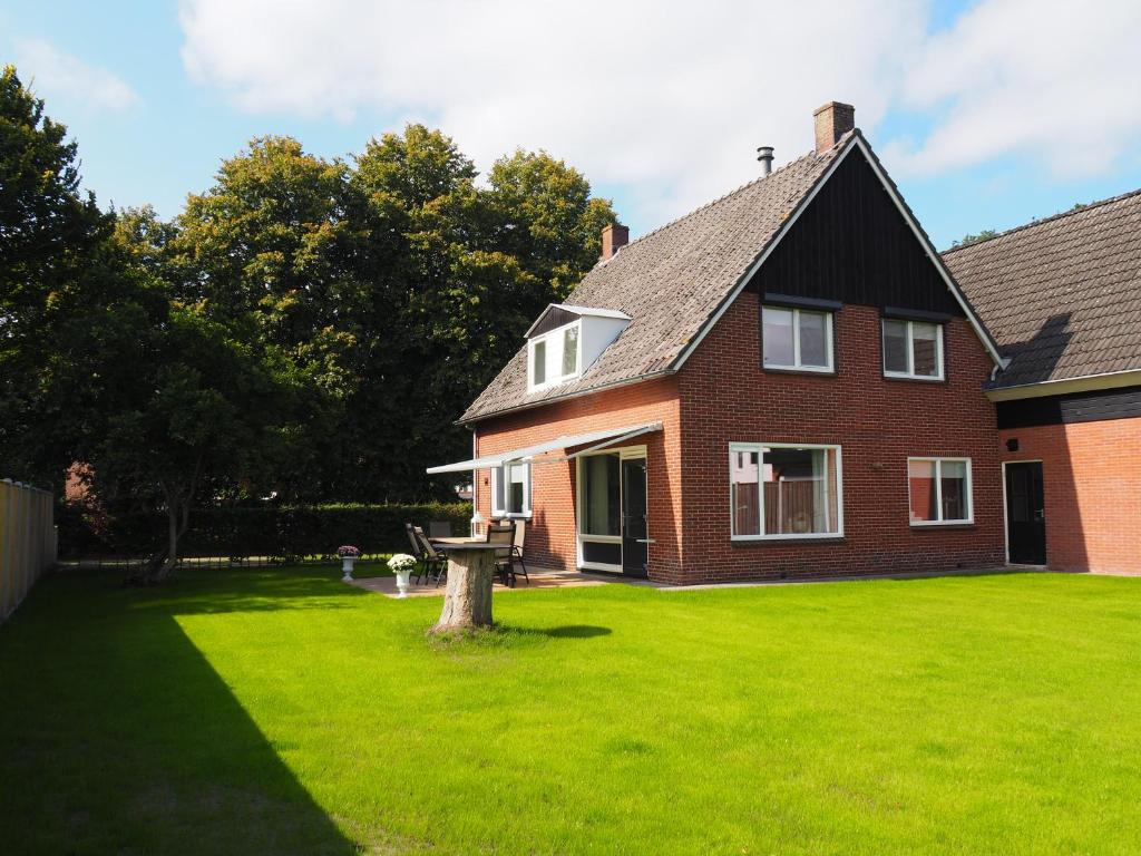 una casa con un césped verde delante de ella en Reggezicht; Mooi huis op een prachtige plek! en Hellendoorn