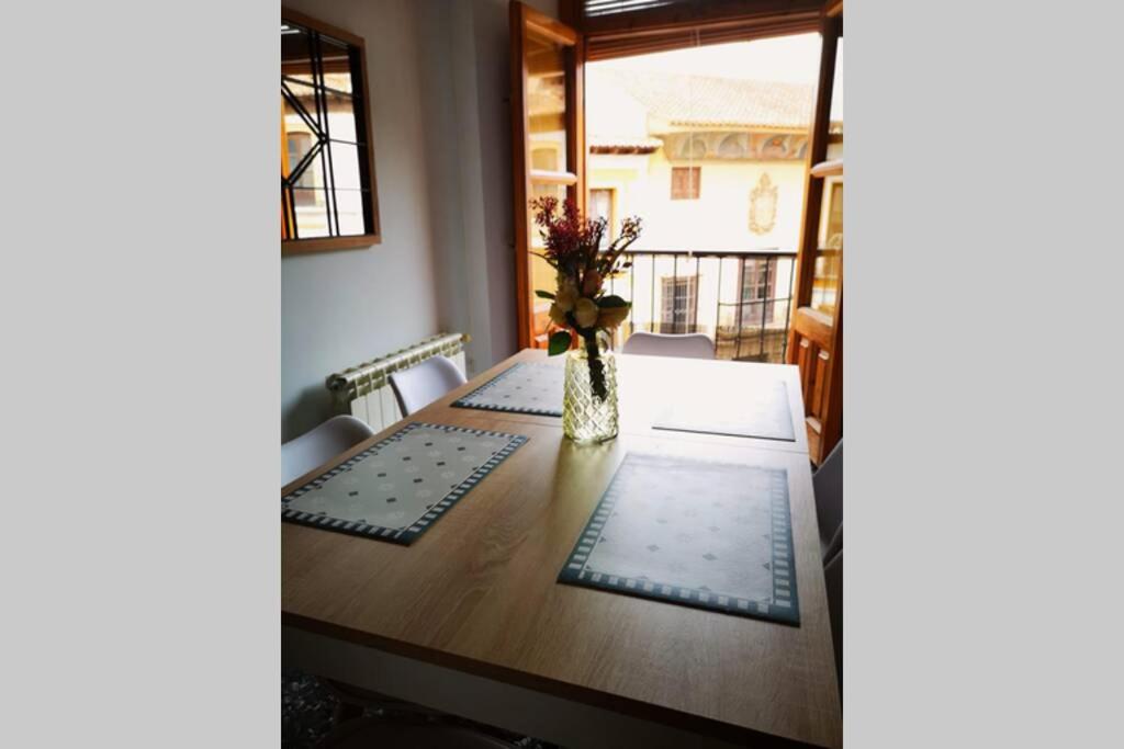 a dining room table with a vase of flowers on it at Casa La Lonja de Guadix in Guadix