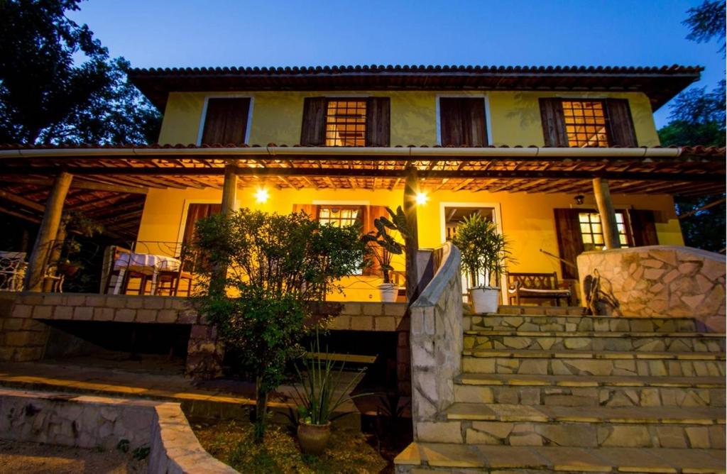 a large yellow house with stairs in front of it at Pousada Casa de Jorge in Lençóis