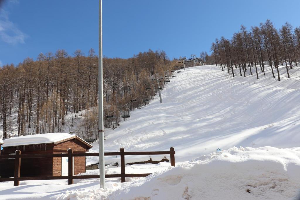 una colina cubierta de nieve con un lodge de esquí. en House Nuova Nube by Holiday World, en Borgata Sestriere