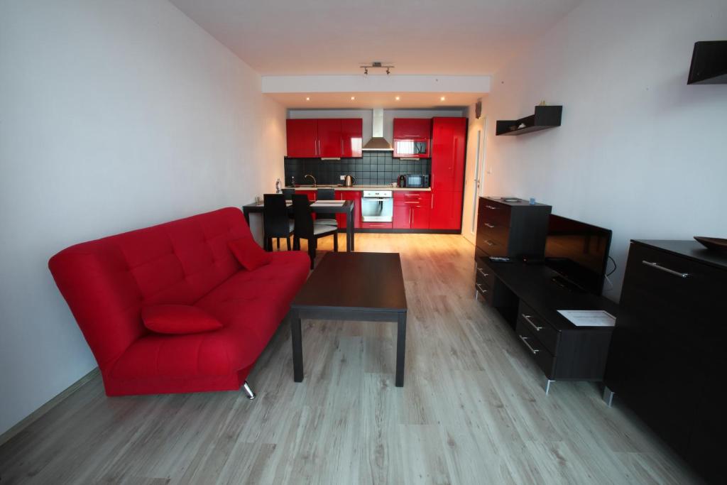 a living room with a red couch and a table at Apartment Park Radouč - 60m2 in Mladá Boleslav