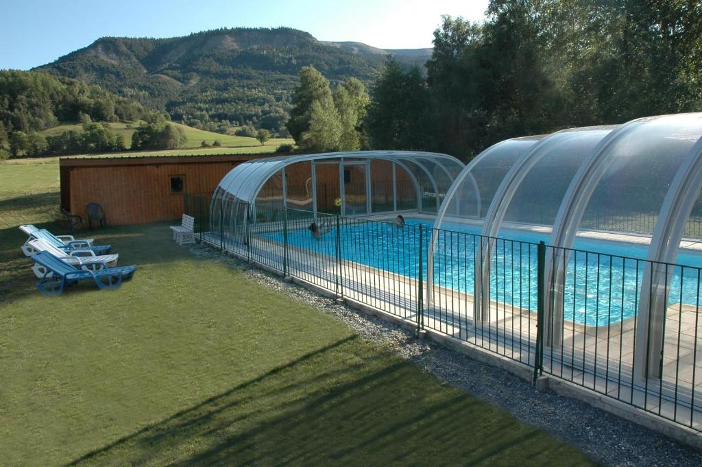 une grande piscine à côté d'un bâtiment dans l'établissement Le Relais de la Forge, à Selonnet