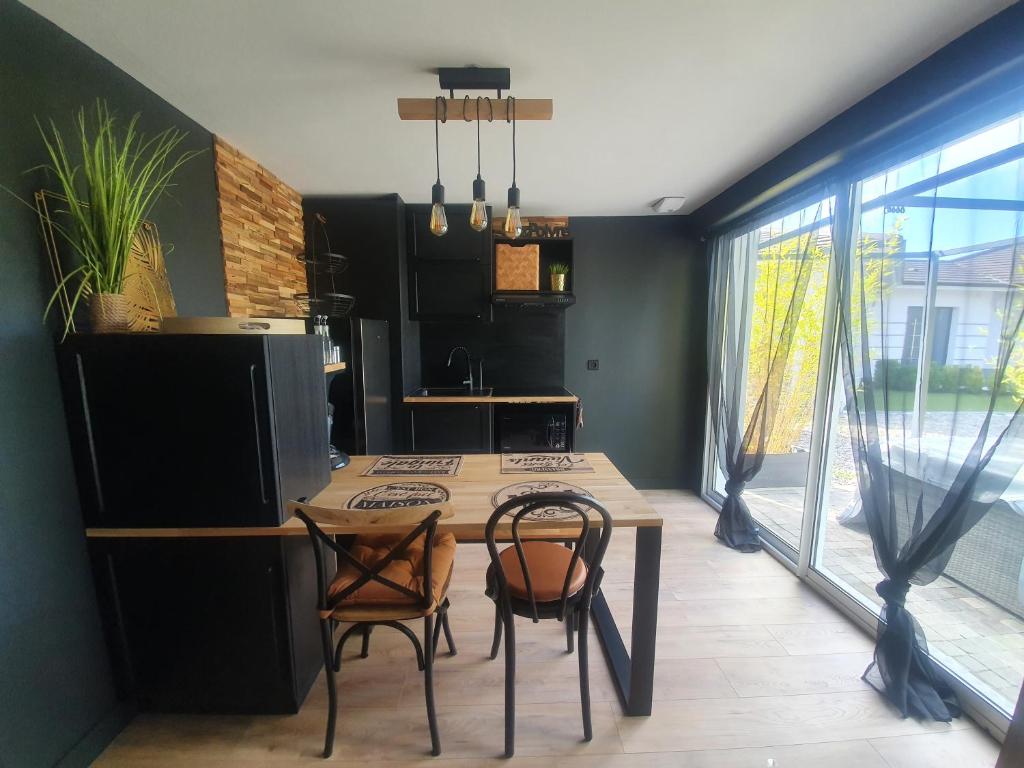 uma cozinha com mesa e cadeiras num quarto em Jungle em Mios
