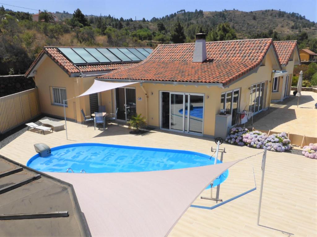 a villa with a swimming pool in front of a house at Finca La Bonita in Puntagorda
