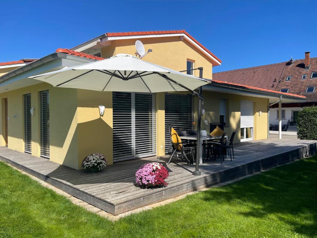a wooden deck with an umbrella and a table at FEWO Sunshine in Villingen-Schwenningen