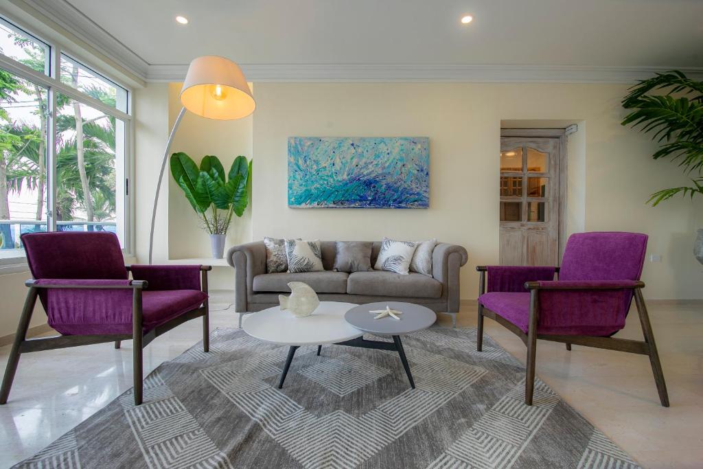 卡塔赫納的住宿－Casa Bahía Apartamento，客厅配有紫色椅子和沙发
