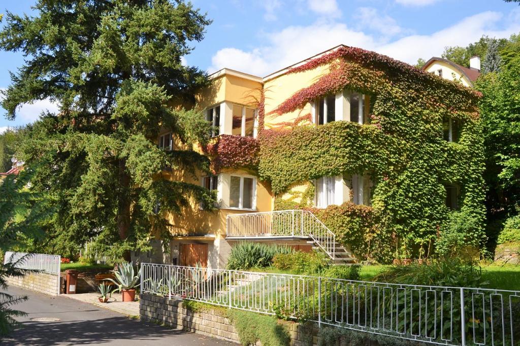 a house covered in ivy on a street at Vila Daniela in Karlovy Vary
