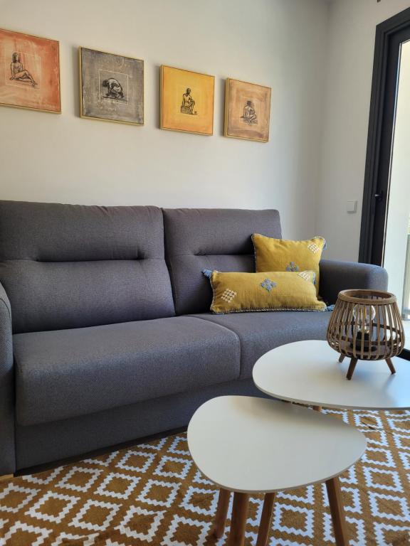 uma sala de estar com um sofá azul e uma mesa em somtresapartament em Platja  d'Aro