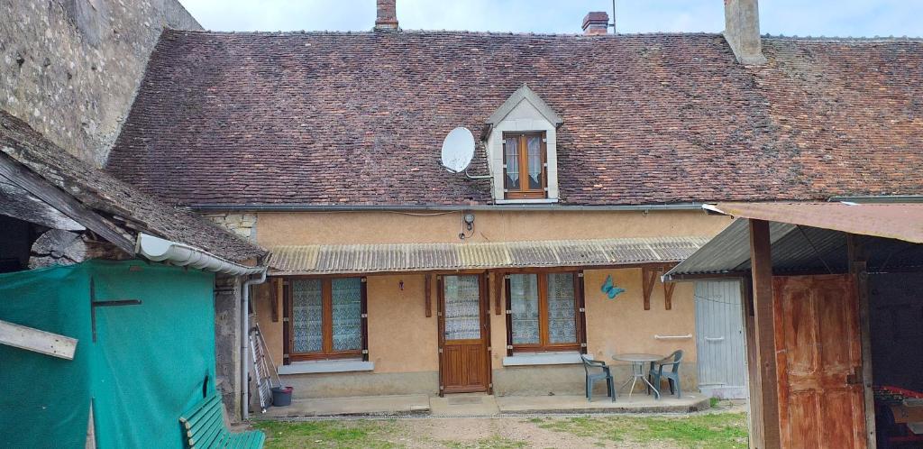 an old house with a roof with a table in front of it at Maison pour nombreuses personnes in Pousseaux