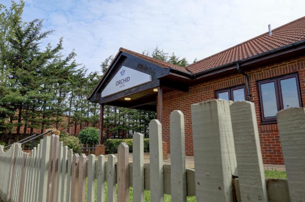 a white picket fence in front of a house at Orchid Epsom; Sure Hotel Collection by Best Western in Epsom