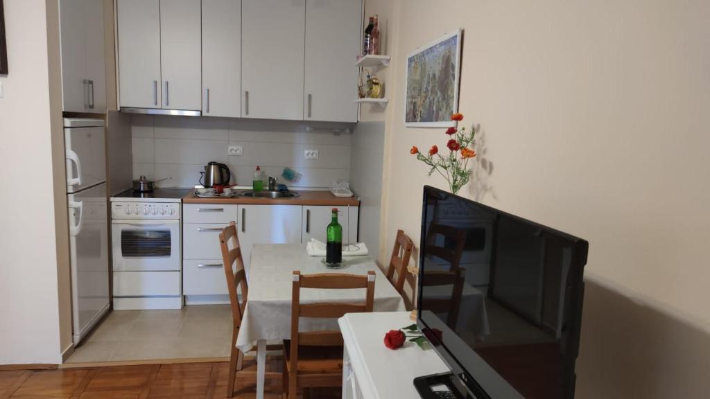 eine kleine Küche mit einem Tisch und einem TV in der Unterkunft Dwell well in Mostar in Mostar