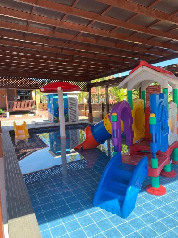 a pool with a playground with a slide and a play equipment at D'Razna Chalet Pantai Seberang Takir in Kuala Terengganu
