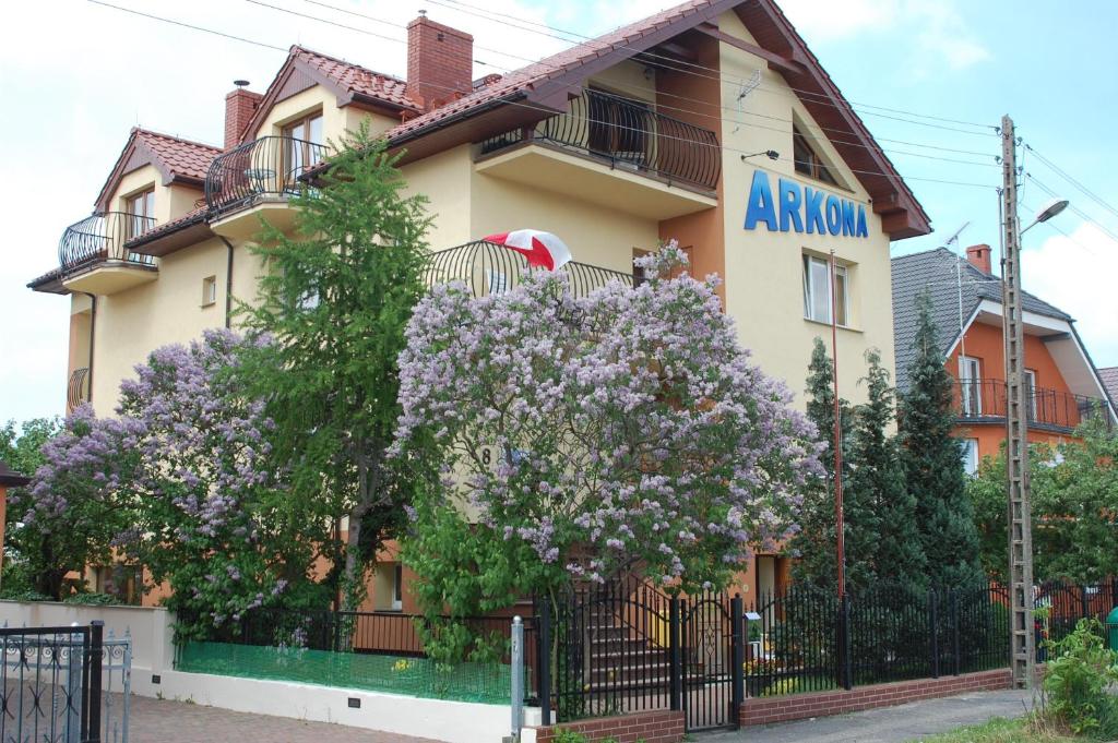 ein Gebäude mit einem blühenden Baum davor in der Unterkunft Arkona in Dziwnówek