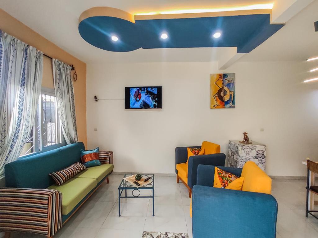 uma sala de estar com dois sofás e um tecto azul em MOOKSQUARE GJ SPOT em Douala